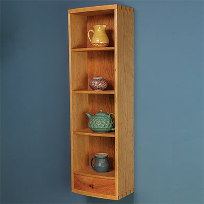 Narrow wooden display cabinet with multiple shelves showcasing decorative pottery.