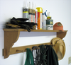 Woodworking wall shelf holding gloves, wood glue, primer, and hanging aprons and hats