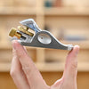 Compact metal WoodRiver apron hand plane held between thumb and forefinger in workshop setting