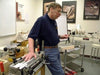 Woodworker demonstrating a Porter-Cable dovetail jig setup in a workshop environment