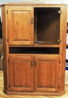 Solid oak corner cabinet with raised panel doors and brass hardware, one door open