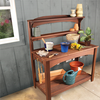 Finished wooden potting bench with gardening tools, pots, and plants in workshop setting