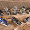 Collection of various metal block planes arranged on rough wood with wood shavings around them