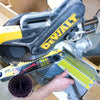 Close-up of a DeWalt miter saw with a hand adjusting the angle gauge for precise cuts