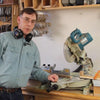 Woodworker demonstrating a miter saw with flip stop setup for multiple cuts in workshop